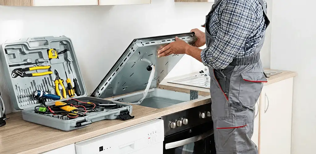 Handyman repairing a cooktop and checking wiring connections in Miami, FL
