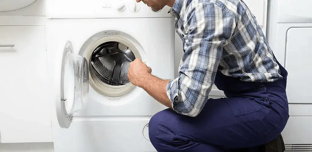 Handyman inspecting a dryer drum and internal parts for repair in Miami, FL