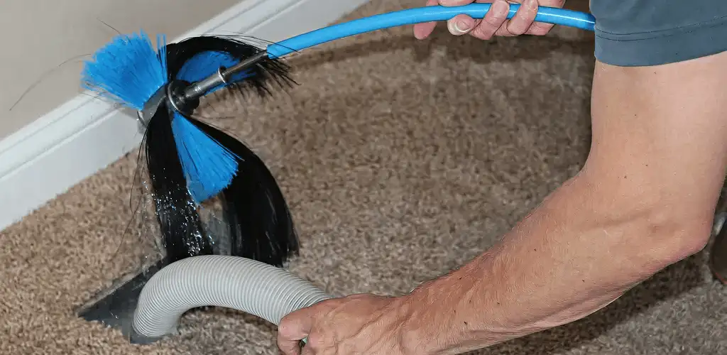 Dryer vent cleaning technician brushing lint from a vent line in Miami, FL