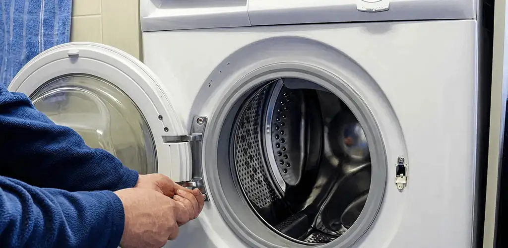 Washing machine repair handyman checking a front-load washer door and latch in Miami, FL