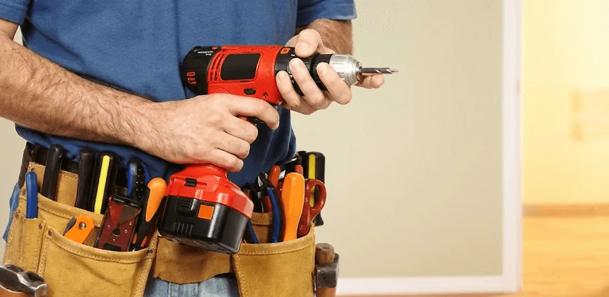 Handyman holding a power drill for home repairs and installations in Miami, FL