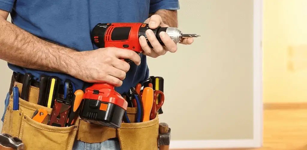 Handyman holding a power drill for home repairs and installations in Miami, FL