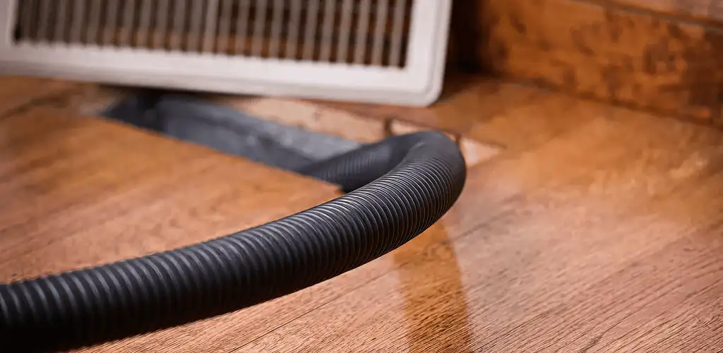 Air duct cleaning hose inserted into a floor vent for ductwork cleaning in Miami, FL