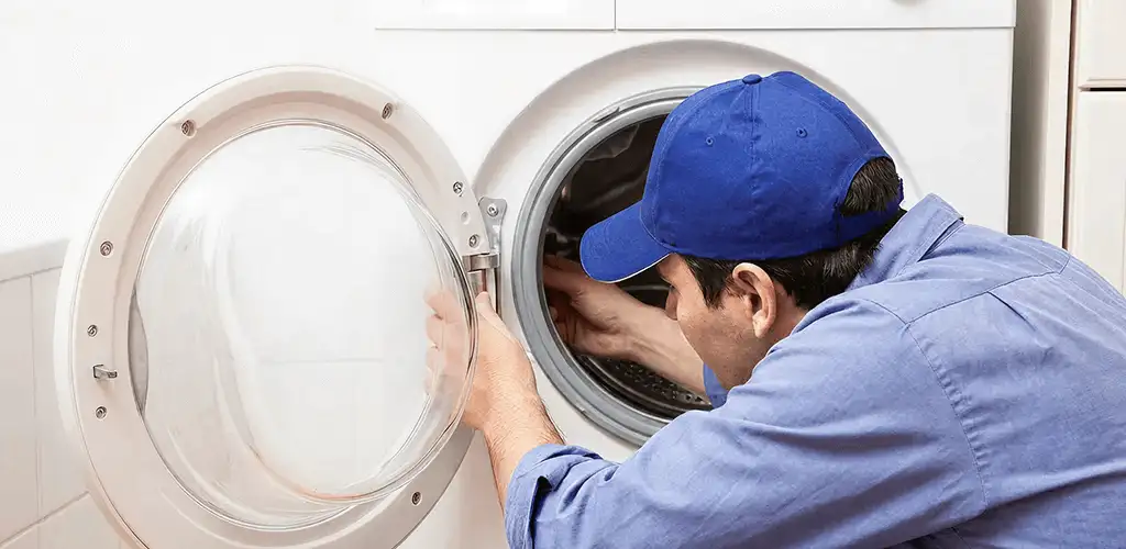 Washing machine repair handyman inspecting a front-load washer drum in Miami, FL